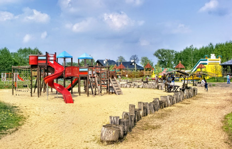 Plac zabaw, dmuchańce i park linowy w tle Plac zabaw, dmuchańce i park linowy w tle